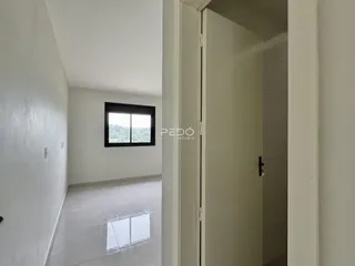 Hall de entrada com piso claro e parede branca em imóvel no Brasil.