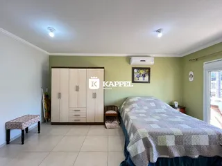 Quarto com cama e armário de madeira em um ambiente claro.