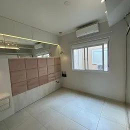 Ambiente interno com piso claro e espelho grande em um imóvel.