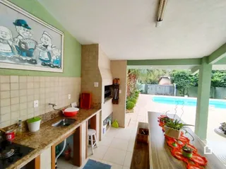 Vista da cozinha com parede verde e acesso à área externa