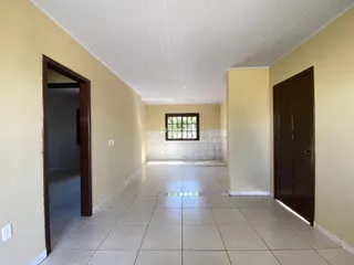 Corredor interno de uma residência com piso de cerâmica clara.