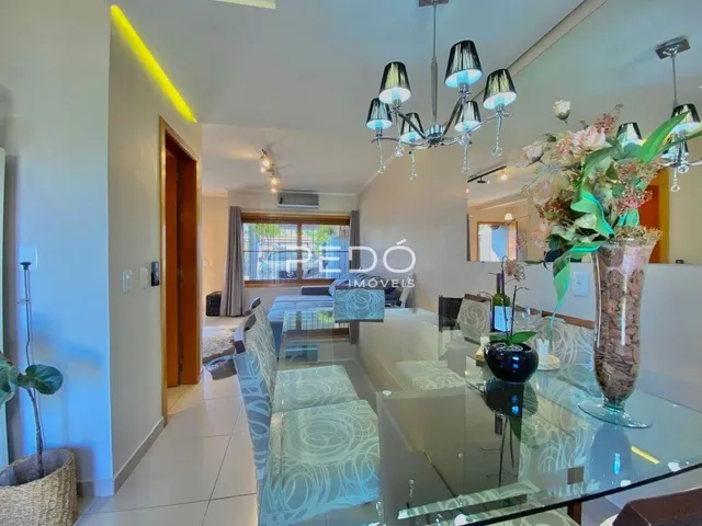 Vista da sala de estar com decoração clara e mesa de vidro.
