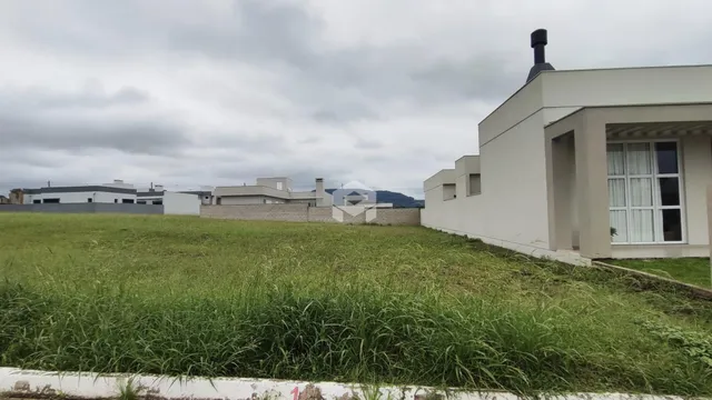 Fachada de uma casa branca com grande área gramada verde.