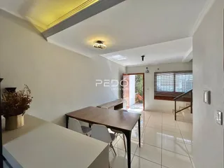 Ambiente interno de sala com mesa de jantar e piso de cerâmica.
