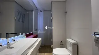 Foto de um banheiro moderno com bancada branca e vaso sanitário.