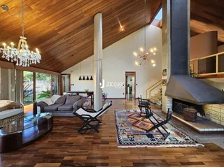 Sala de estar com piso de madeira e teto inclinado de madeira.