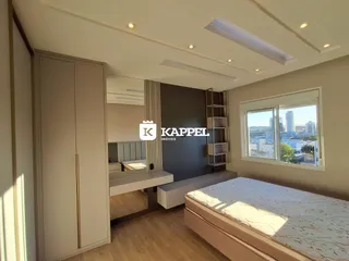 Quarto com cama grande e janela com vista para a cidade.