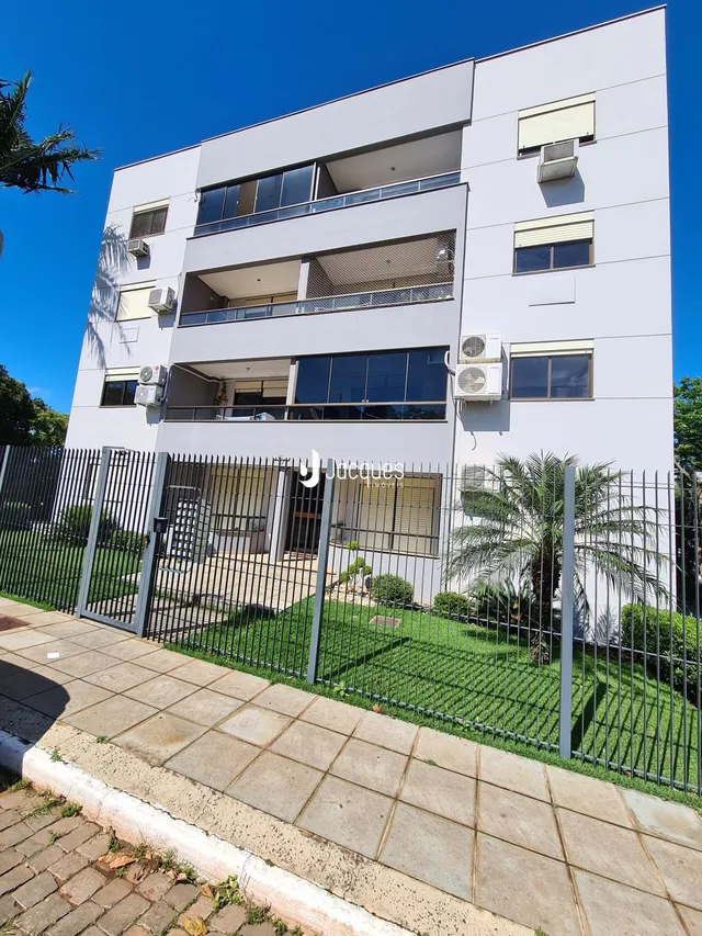 A fachada de um prédio residencial em Lajeado, Brasil com jardim e cerca.