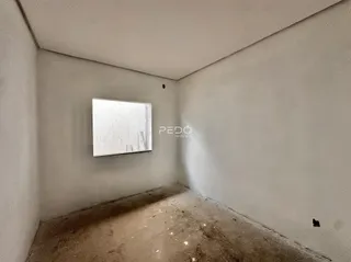 Interior de um cômodo com piso de concreto aparente e paredes lisas.