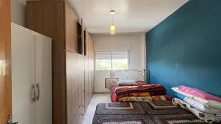 Quarto com armários de madeira e cama no interior de uma residência.