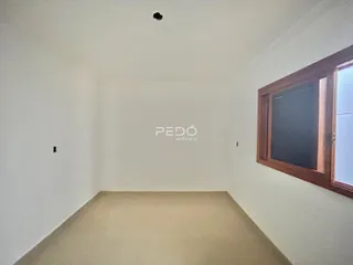 Foto de um cômodo interno com paredes brancas e piso claro.