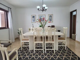 A sala de jantar apresenta uma mesa grande com cadeiras de madeira.
