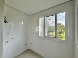 Hall de entrada com parede branca e janela de grande porte.