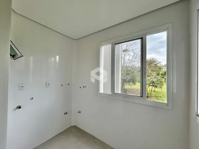 Hall de entrada com parede branca e janela de grande porte.