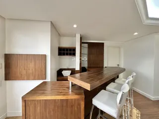 Interior da cozinha com ilha de madeira e armários.