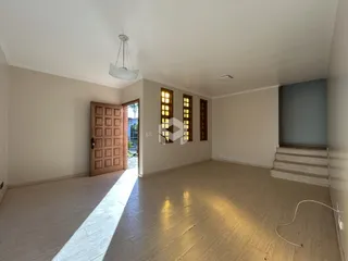Sala ampla com piso de madeira clara e paredes brancas.