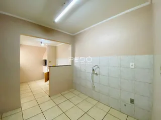 Corredor interno com piso de cerâmica e parede revestida.
