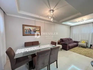 Sala de jantar com mesa de madeira no interior da residência.