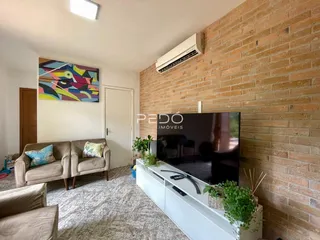 Sala de estar com sofá e televisão em um imóvel no Brasil.