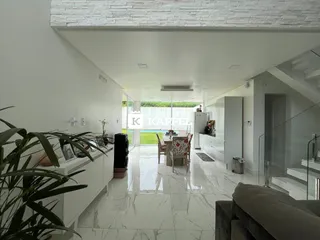 Ambiente amplo com piso claro e área de jantar integrada em um imóvel.