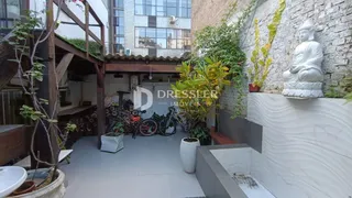 Vista externa de um pátio com parede de pedra e vegetação em Lajeado.