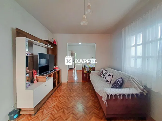 Uma sala de estar com sofá e painel de TV em um ambiente claro.