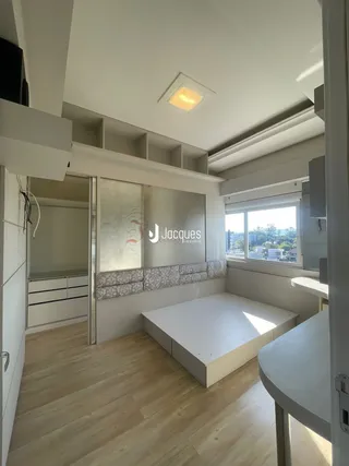 Quarto com piso de madeira e estantes embutidas em um imóvel.