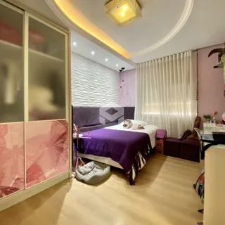 Quarto com cama grande e cortinas brancas em ambiente claro.