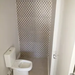 Foto de um banheiro com revestimento de azulejos brancos.