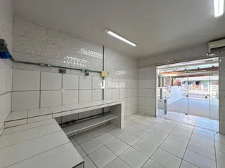 Interior com revestimento de cerâmica branca e piso de cerâmica no imóvel.