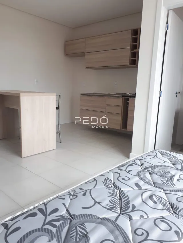 Quarto com cabeceira e armários de madeira em um imóvel.