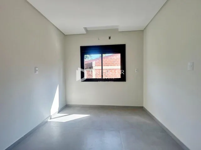 Interior de um espaço com uma grande janela de tijolos à vista.
