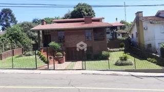 Fachada de uma casa residencial em Lajeado, Brasil, com cerca e jardim na frente.