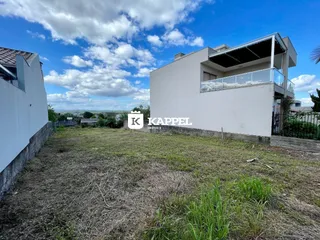 Fachada de uma casa branca moderna em Lajeado com um gramado em primeiro plano.