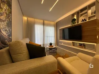 Sala de estar moderna com sofá e painel de madeira.