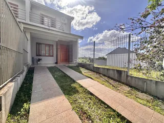 Vista da fachada de uma residência com jardim e cerca em Lajeado, Brasil.