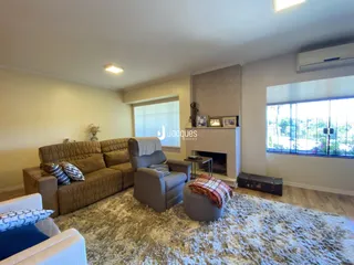 Sala de estar com sofá e poltronas em um ambiente claro.