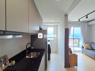 Foto da cozinha moderna com armários superiores e bancada escura.