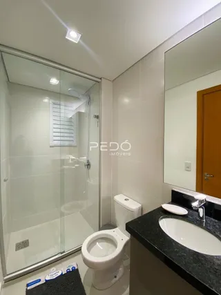Foto de um banheiro moderno com box de vidro e louças sanitárias.