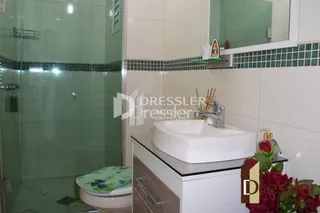 Foto de um banheiro com azulejos brancos e bancada branca.