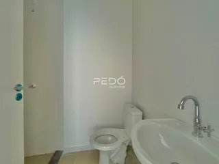 Foto de um banheiro interno com louças sanitárias brancas.