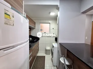 Foto de uma cozinha com armários escuros e eletrodomésticos brancos.