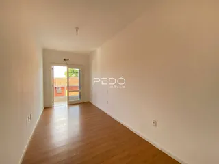 Hall de entrada com piso de madeira clara e paredes brancas.