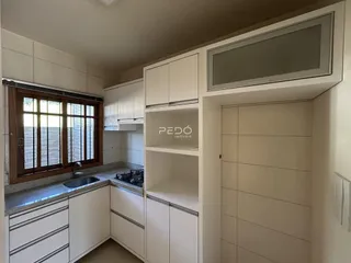 Cozinha com armários brancos e janela.