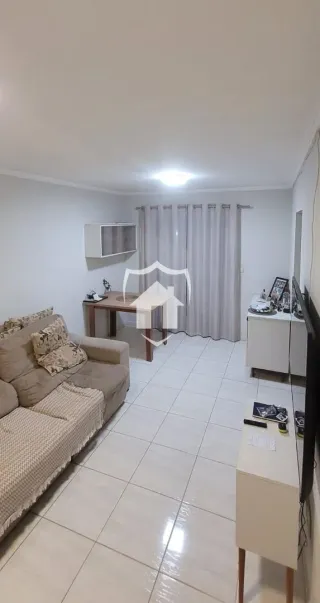 Sala de estar com sofá e cortinas claras.