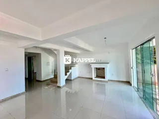 Foto do hall de entrada de uma residência com piso de porcelanato claro e área de estar ampla.
