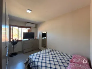 Quarto interno com cama e janela em um imóvel no Brasil.