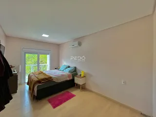 Quarto com cama e janela de vidro na residência.