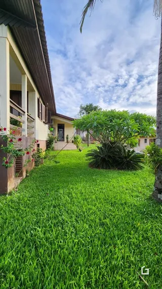 Fachada de uma casa com jardim verde bem cuidado.