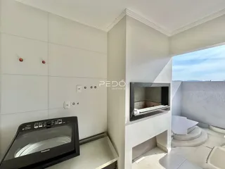 Parede interna branca com eletrodomésticos e abertura para uma área externa.